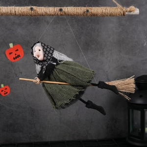 Handmade Halloween witch doll in green dress riding a bamboo broom for festive decoration