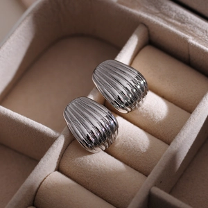Close-up of silver-plated stainless steel shell earrings with vertical texture