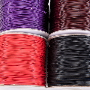 Detail shot of purple, brown, red and black waxed cords for DIY jewelry weaving