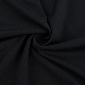 Gros plan sur le tissu en maille noire montrant d'élégants détails de plis en spirale