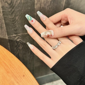 Handmade long trapezoidal Christmas press-on nails with white snowflakes and festive art