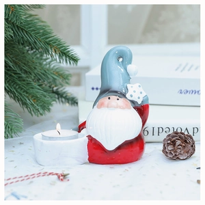 Detail of Christmas gnome ceramic candle holder with red body and white tea light