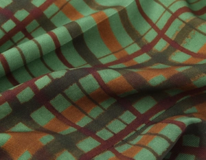 Detailed close-up of green and brown plaid fabric texture with soft drape and weave