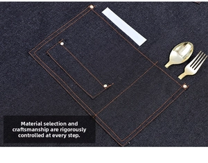 Detailed close-up of dark blue denim apron pocket with reinforced metal rivets and stitching