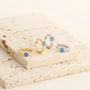 Detailed view of bamboo texture earrings with blue opal stones in gold and silver finish