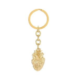 Golden anatomical heart keychain in polished stainless steel on a white background