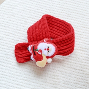 Close-up of red knitted pet scarf with Santa Claus decor for Christmas and New Year