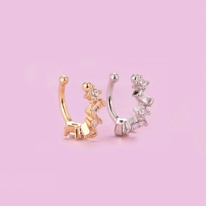 Macro detail of wave-shaped ear cuffs in gold and silver plating with cubic zirconia gems