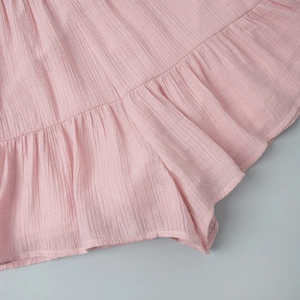 Detail of light pink ruffled hem with textured pleated fabric for summer shorts set