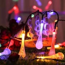 Outdoor solar string lights with multicolor water drop bulbs on a wooden boat model