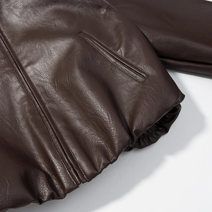Detail of dark brown faux leather jacket texture with metal zipper and hem stitching