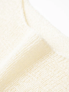 Close-up of cream knit sweater showing premium textured crochet fabric and seam details
