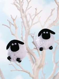 Détail de suspensions agneau en peluche avec têtes en feutre noir sur branches corail