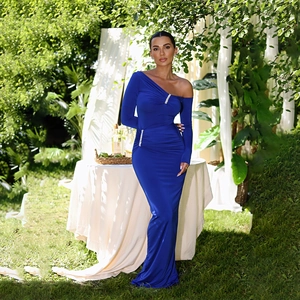 Detail of blue one-shoulder long sleeve dress with side slit and rhinestone accents