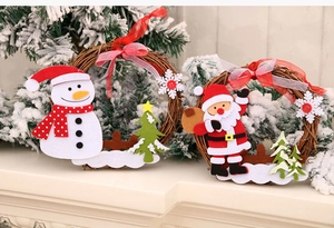 Detail of Christmas rattan wreaths with Santa and snowman figures on a cozy white fireplace