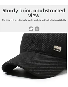 Detail of the black corduroy baseball cap showing the stiff brim and metal fashion logo