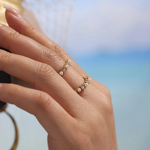 Anello aperto dorato alla moda con perle bianche e cristalli scintillanti sulle dita