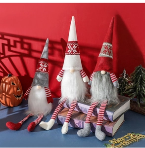 Close-up of Nordic Christmas gnomes with knit hats and long legs on a festive table