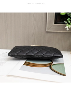 Vue détaillée du sac bandoulière noir matelassé avec logo en métal doré élégant