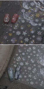 Macro detail of Christmas nail decals with gold snowflakes and star patterns for manicure
