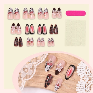 French almond press-on nails with zebra stripes, floral patterns and red cherry designs