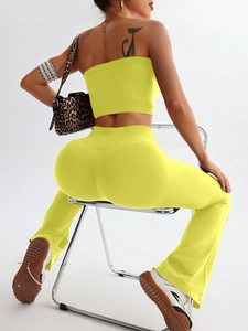 Detail of high-waisted flared yoga pants and tube top in vibrant fluorescent yellow