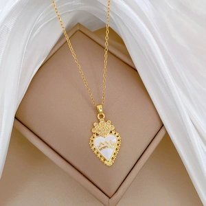 Elegant gold titanium crown heart pendant necklace with zircon on a soft beige background