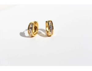 Macro shot of gold hoop earrings with clear cubic zirconia inlay and polished finish