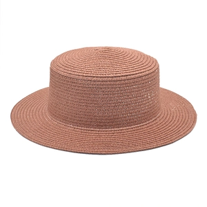 Close-up of finely woven texture on a dark brick red straw boater hat with a flat top