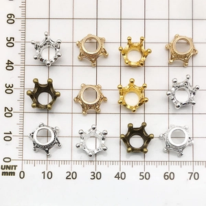 Macro view of assorted crown-shaped alloy jewelry beads with scale measurement in mm