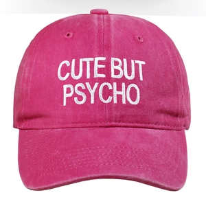 Close-up of 'CUTE BUT PSYCHO' white embroidery on hot pink cotton baseball cap