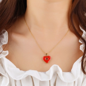 Collier en plaqué or 18 carats avec pendentif coeur émaillé rouge porté par un mannequin