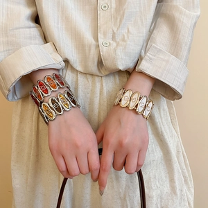 Close-up of vintage enamel geometric link stretch bracelets on a model wrist