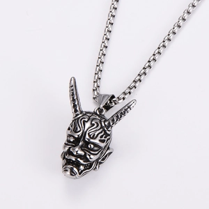 Detailed close-up of a vintage silver bull skull pendant with intricate facial carvings
