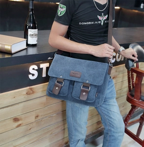 Detail showing blue canvas messenger bag with brown leather straps and front pockets