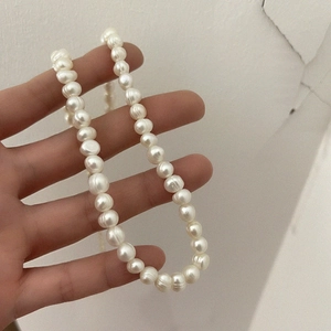 Close-up of irregular Baroque freshwater pearls necklace with natural luster held in hand