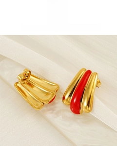 Detail of 18k gold plated stainless steel earring with red enamel on white silk
