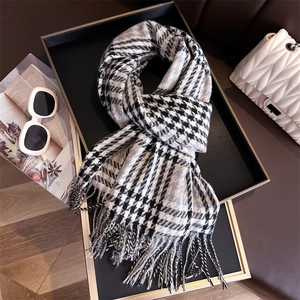 Classic black and white checkered scarf with fringe on a tray with fashion accessories