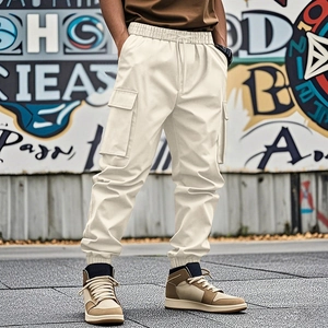 Detail of loose fit cargo joggers in beige with side flap pockets and cuffed ankles