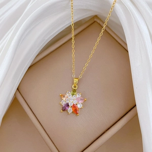 Luxurious gold-tone flower pendant necklace with colorful gems on white silk