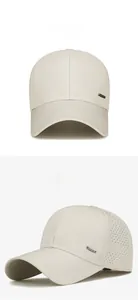 Detail of beige quick-dry mesh cap showing side laser-cut vents and metal brand plate