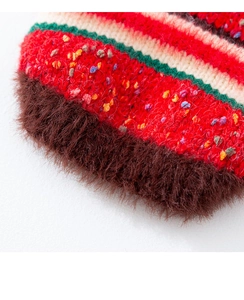 Detail of colorful striped dog sweater fabric with red, green and brown faux fur trim
