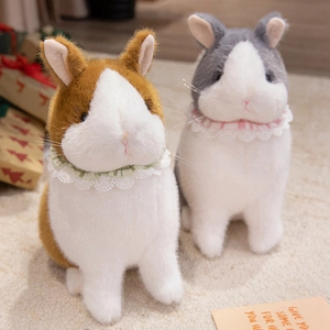 Plush bunny toy set in brown and gray with lace collar in a warm home setting
