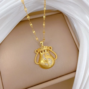 Macro shot of gold money bag pendant with crystal dollar sign on silk fabric