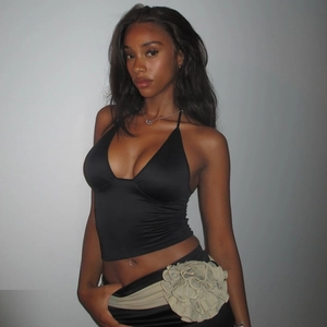Détail d'un haut dos nu noir associé à une jupe ornée de grandes fleurs de couleur beige