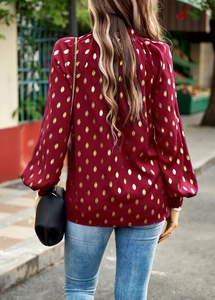 Back view of burgundy long sleeve blouse with golden leaf print and elastic cuffs
