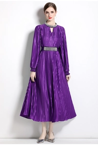 Detailed view of dark purple pleated dress with waist embellishment and metallic luster