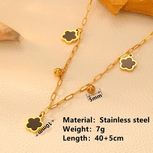 Golden stainless steel necklace with black clover charms and gold beads on elegant background