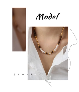 Detailed close-up of Tiger Eye stone and freshwater pearl beaded necklace with gold clasp