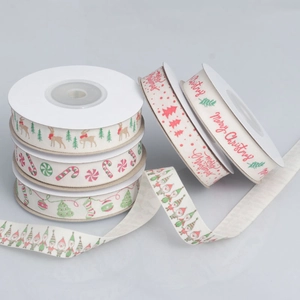 Rolls of cream Christmas ribbon with reindeer, tree patterns and Merry Christmas text